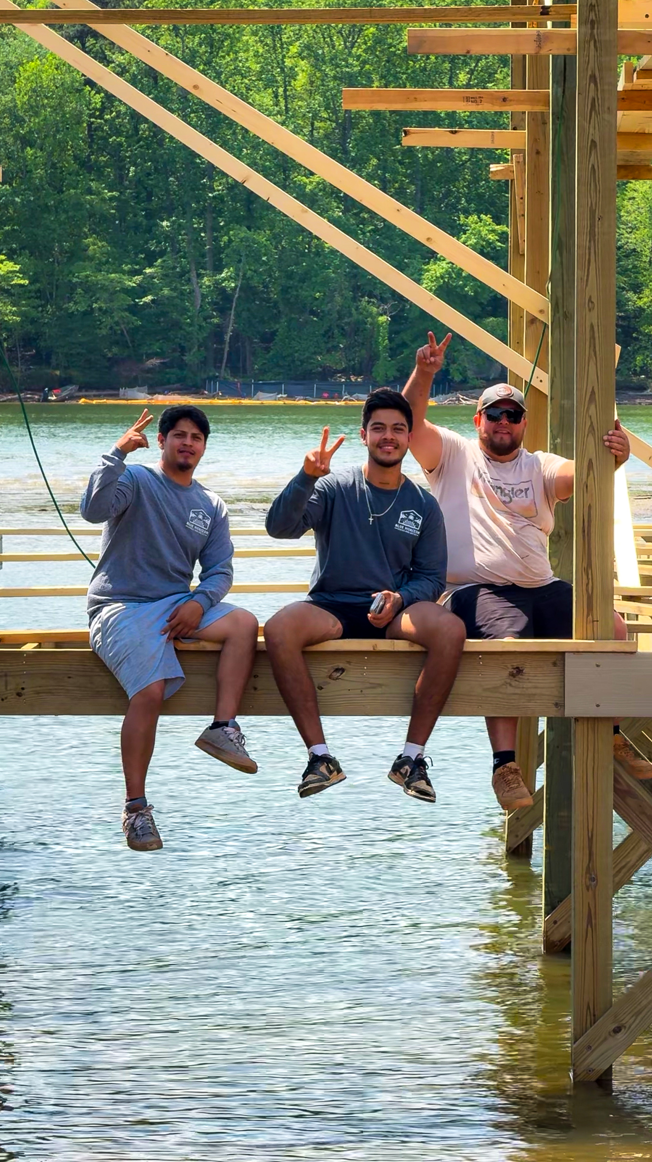 Blue Horizon crew sitting on a newly finished dock at a Tennessee lake