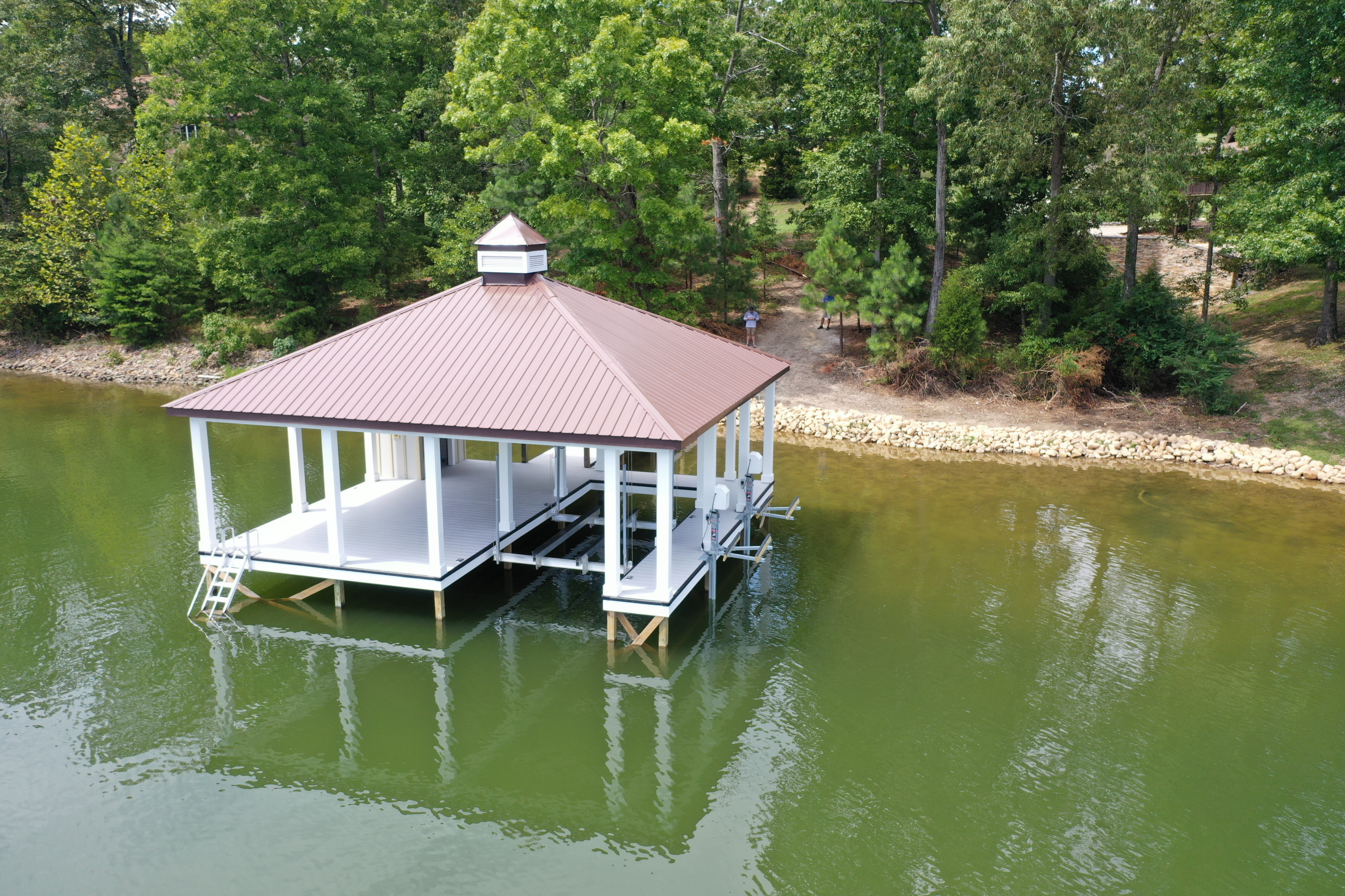 Finished fixed dock with burgundy metal roof and cedar trim on an East Tennessee lake