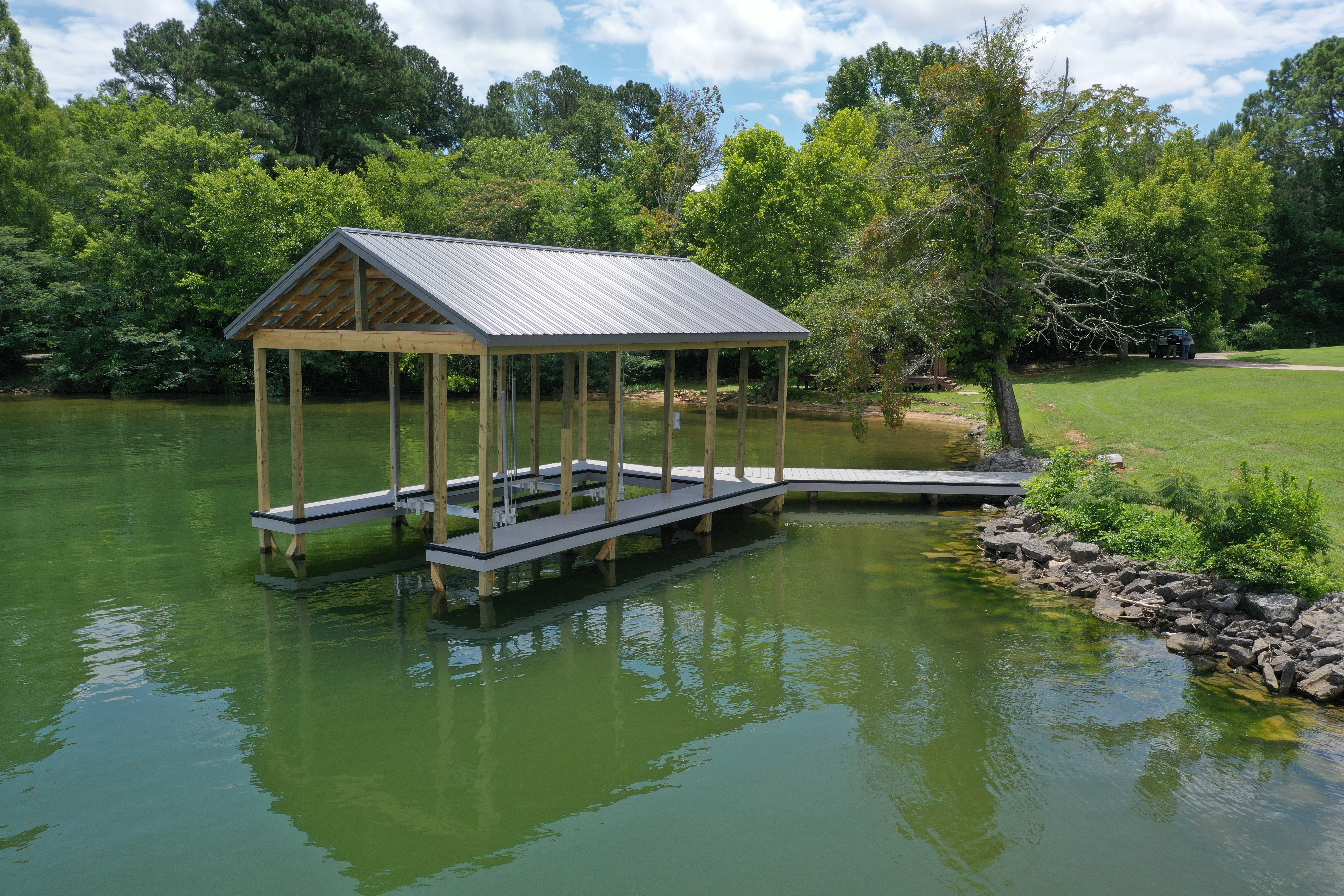 Custom fixed dock with metal roof on a Tennessee lake cove